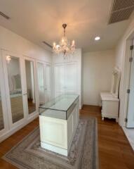 Spacious walk-in closet with chandelier and multiple mirrors