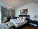 Spacious bedroom with a large bed and elegant chandelier