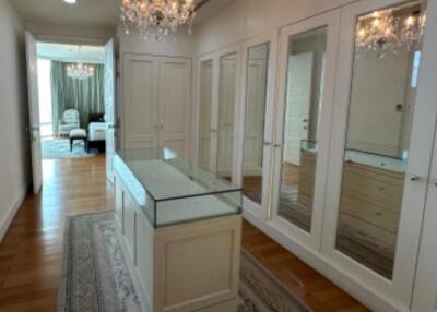 Elegant walk-in closet with glass top island and chandelier