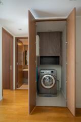 Compact laundry area with washing machine and storage cabinets