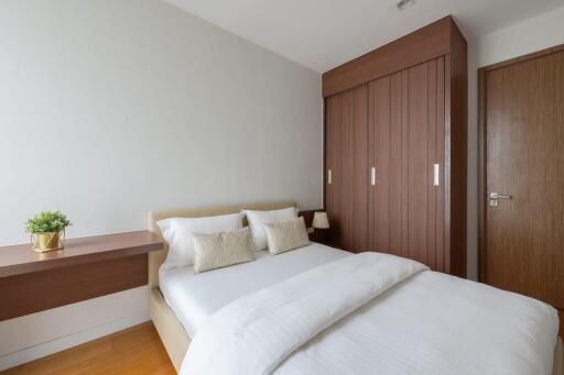 Modern bedroom with a double bed, wooden wardrobe, and bedside table