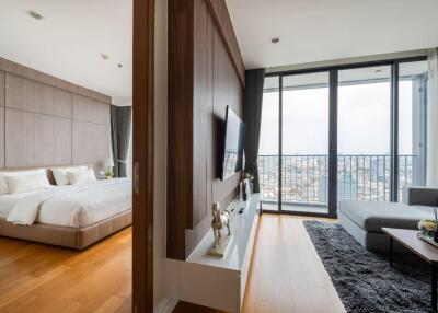 Modern bedroom and living area with large windows and city view