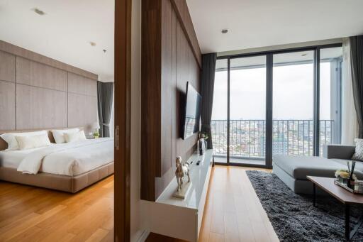 Modern bedroom and living area with large windows and city view