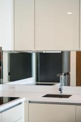 Bright modern kitchen with white cabinets and stainless steel fixtures