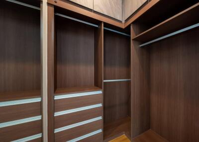 Spacious walk-in closet with wooden cabinetry and built-in shelves