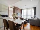 Modern living room with large windows, a dining table, and a gray sofa