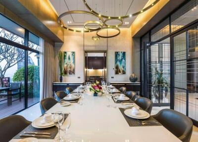 Elegant dining room with a large table set for dinner and modern chandeliers