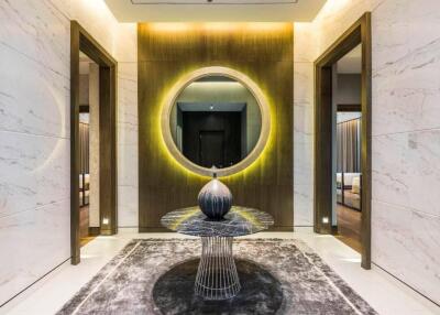 Elegant and modern hallway with a unique marble table and circular mirror