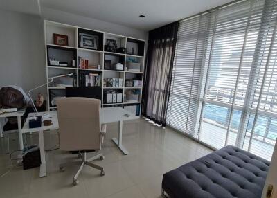 Modern home office with large windows and organized bookshelf