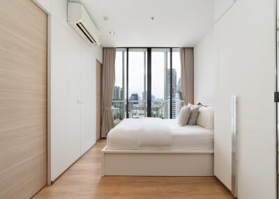 Modern bedroom with large windows and city view