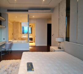 well-lit modern bedroom with adjacent bathroom