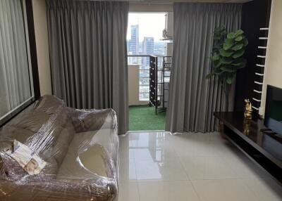 Living room with a couch, television, and balcony view