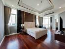 Spacious and modern bedroom with large windows, warm wood flooring, and a comfortable bed