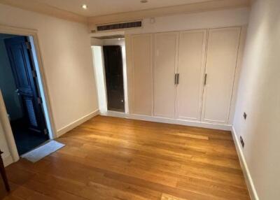 Spacious bedroom with wooden flooring and built-in wardrobes