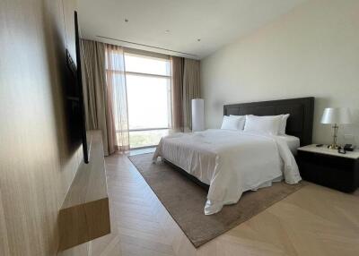 Spacious bedroom with a large window and modern furnishings