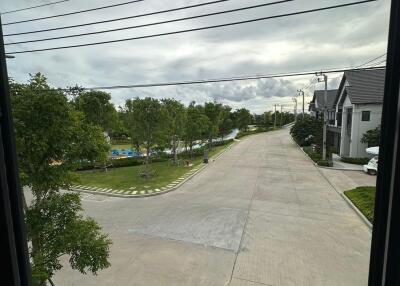 View outside from a window showing a street with houses and trees