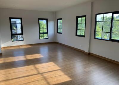 Spacious living room with large windows and wooden flooring