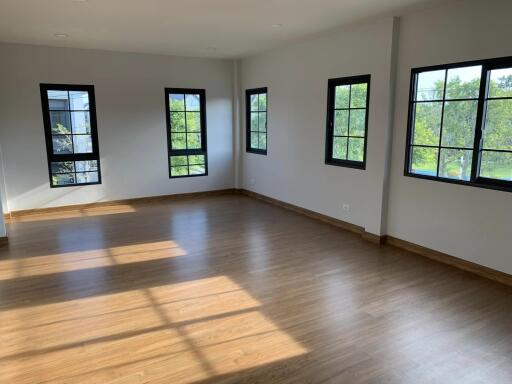 Spacious living room with large windows and wooden flooring