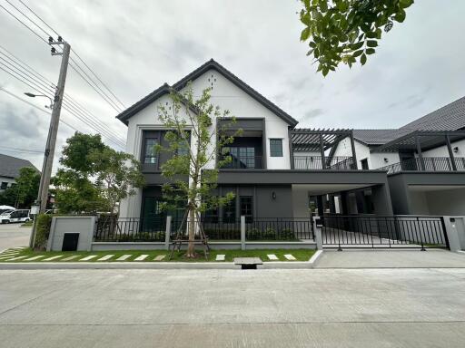 Modern multi-story house with attached carport and landscaped yard