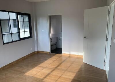 Spacious bedroom with wooden flooring and ensuite bathroom