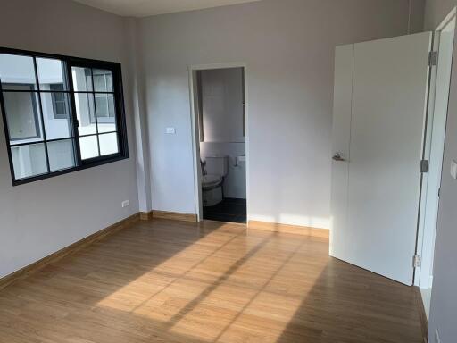 Spacious bedroom with wooden flooring and ensuite bathroom