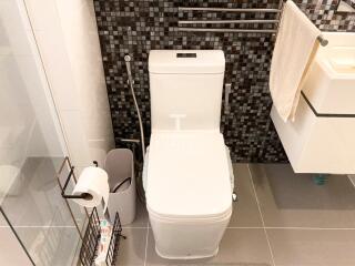 Modern bathroom with toilet, sink, and shower