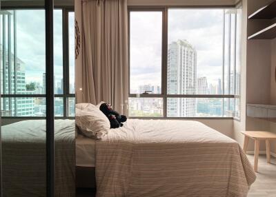 Spacious bedroom with a large window offering a city view