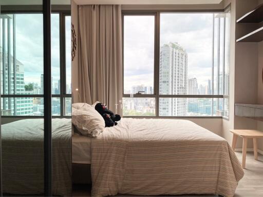 Spacious bedroom with a large window offering a city view