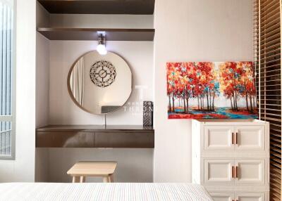 Modern bedroom with decorative mirror, artwork, and stylish furniture