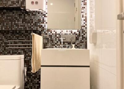 Modern bathroom with mosaic tile wall and white fixtures