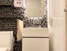 Modern bathroom with mosaic tile wall and white fixtures