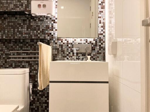 Modern bathroom with mosaic tile wall and white fixtures