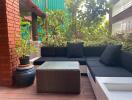 Outdoor seating area with black cushions and greenery