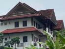 Exterior view of a multi-story building with red tiled roof and balconies