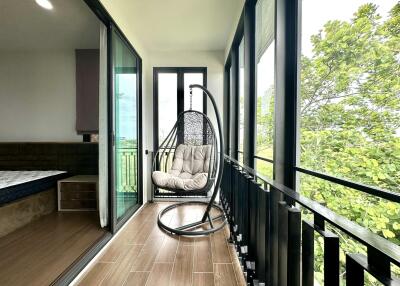 Spacious balcony with swing chair and large windows