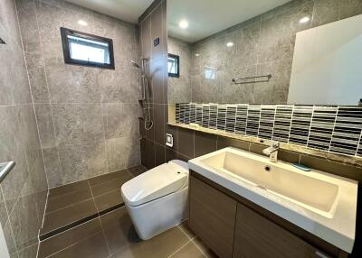 Modern bathroom with glass shower, toilet, and vanity sink