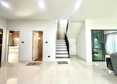 Main living area with stairs, adjacent kitchen, and bathroom