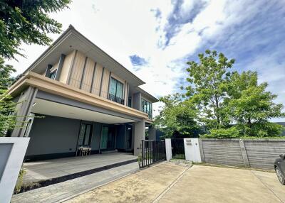 Modern two-story house with driveway and greenery