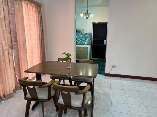 Dining area with a four-seater table and view into the kitchen