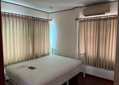 Bedroom with bed and curtained windows