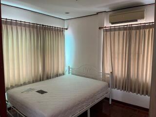 Bedroom with bed and curtained windows