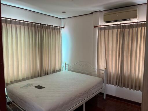 Bedroom with bed and curtained windows