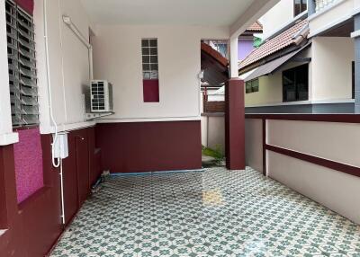 Covered balcony area with patterned floor tiles and air conditioning unit