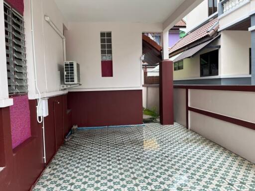 Covered balcony area with patterned floor tiles and air conditioning unit