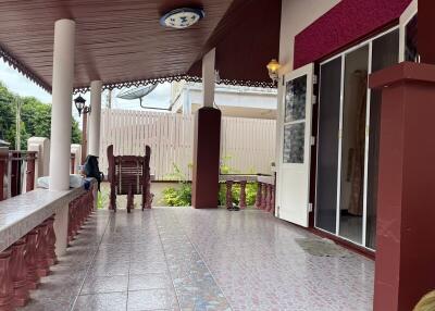 Covered outdoor patio with tiled flooring and seating