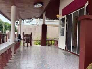 Covered outdoor patio with tiled flooring and seating