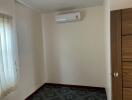 Small empty bedroom with air conditioner and a large wooden closet