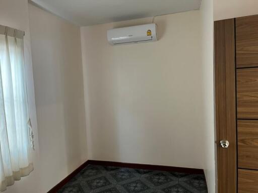 Small empty bedroom with air conditioner and a large wooden closet