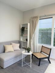 A cozy living room with a sofa, chair, coffee table, and bookshelf.