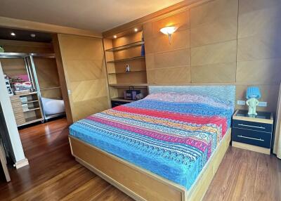 Bedroom with wooden furniture and colorful bedspread